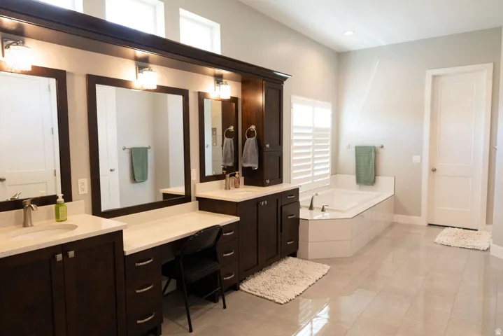 Dual vanities with undermount sinks, built-in cabinetry, and integrated lighting