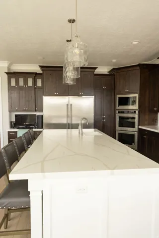 Expansive kitchen island with a light-toned countertop, integrated sink, and brushed nickel faucet