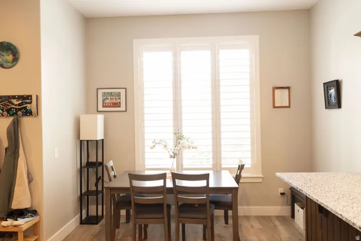 Wood-finish flooring, white window shutters, and a built-in counter with a speckled surface