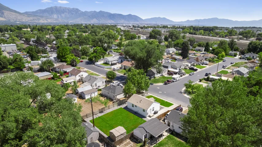 Residential neighborhood with established trees, paved streets, and mountain ranges in the distant background