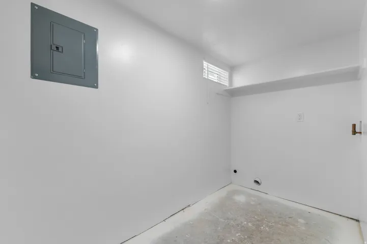 Built-in shelving, concrete flooring, and an electrical panel