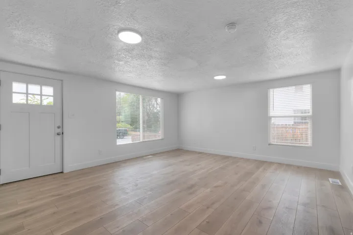 Light wood-finish flooring with white walls