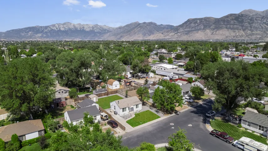 Residential neighborhood with established trees, paved streets, and mountain ranges in the distant background