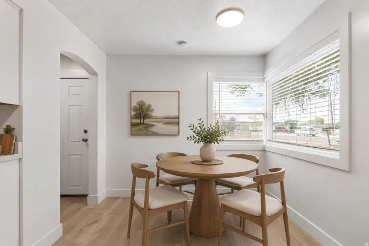 Virtually staged. Wood-finish flooring, white walls, arched doorway, recessed lighting, and corner windows