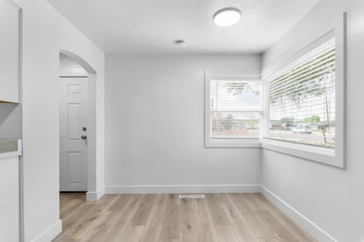 Light wood-finish flooring with white baseboards
