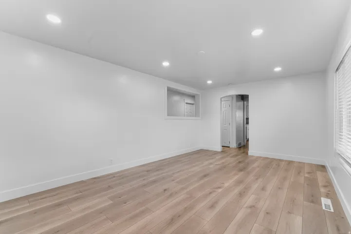 Recessed lighting, wood-finish flooring, white walls, and a window with blinds