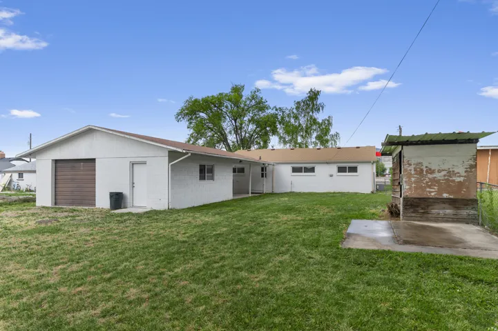 Expansive grassy yard with a detached garage structure and an additional shed