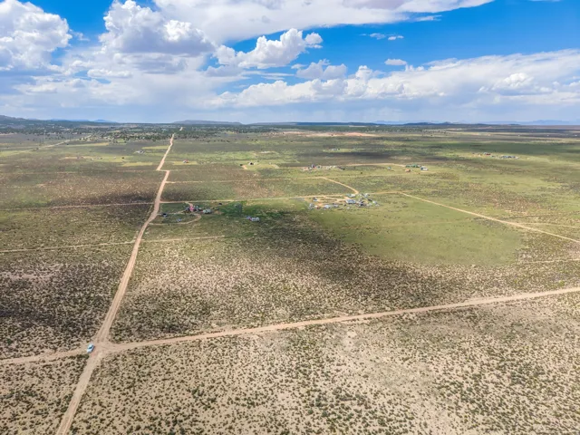 Expansive rural landscape with established unpaved roads and distant structures