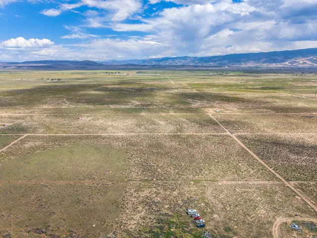 Expansive open terrain with distant mountain ranges and scattered dry vegetation