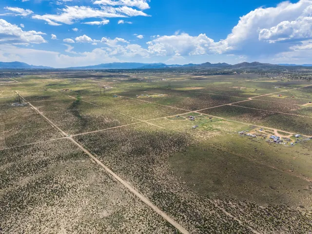 Expansive desert landscape featuring natural vegetation and distant mountain ranges