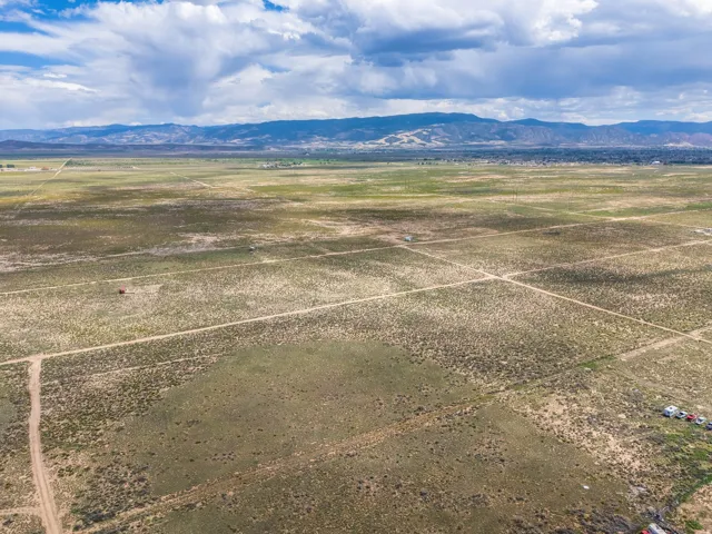 Expansive open land with distant mountain ranges and scattered vegetation