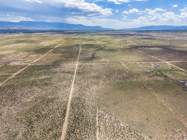 Expansive land parcel with unpaved road access and distant mountain backdrop