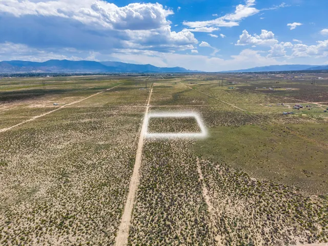 Expansive desert landscape with a designated property boundary and distant mountains