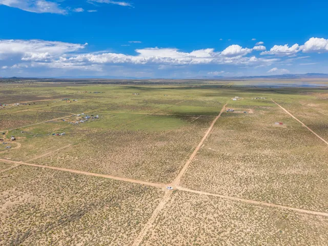 Expansive open terrain with a dirt road network and distant structures