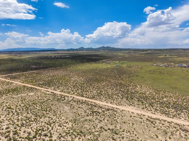 Expansive undeveloped land featuring a clear dirt road and distant mountain range