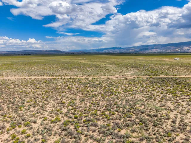 Expansive open terrain with natural vegetation and distant mountain ranges