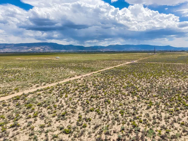 Expansive undeveloped land featuring natural vegetation and distant mountain ranges