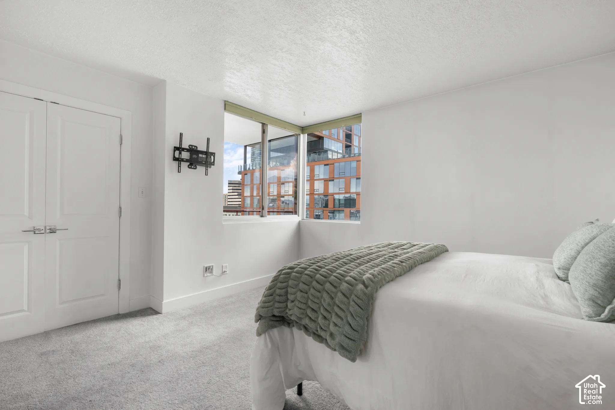 Owners suite with corner windows and an urban backdrop