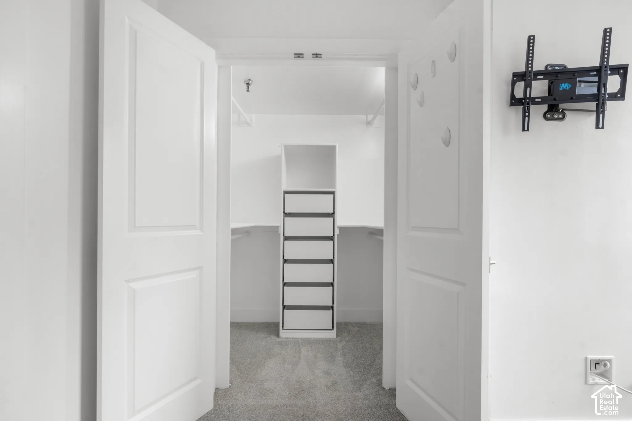 Double panel doors opening to a walk-in closet with built-in shelving, drawer storage, and hanging rods