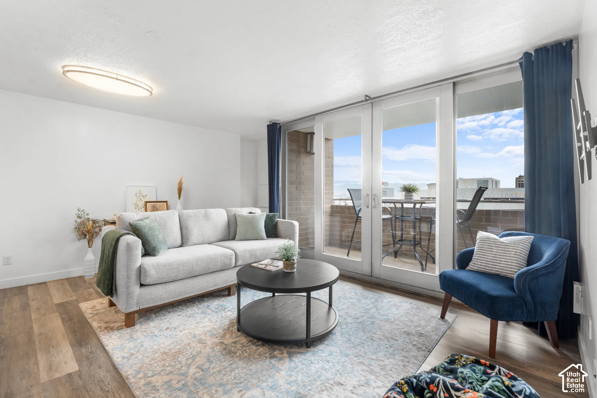 Wood-finish flooring with a multi-pane glass sliding door opening to a balcony