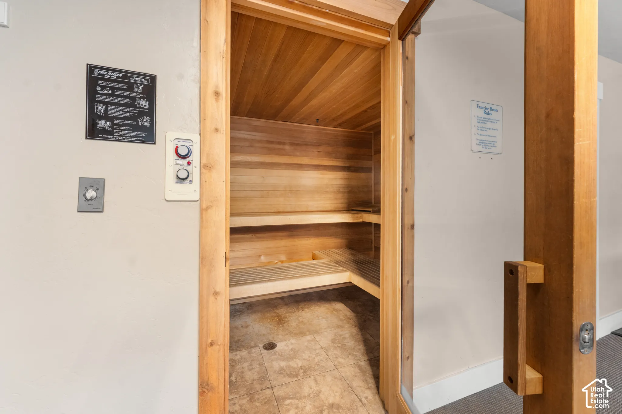 Wood-paneled sauna with built-in bench seating and tiled flooring