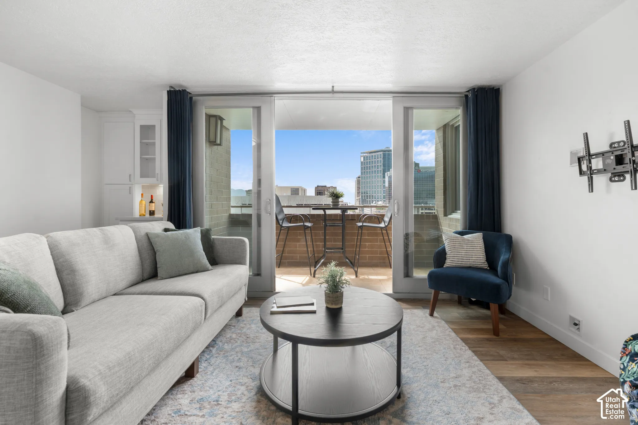 Sliding glass doors opening to an outdoor balcony, built-in white cabinetry, and wood-finish flooring