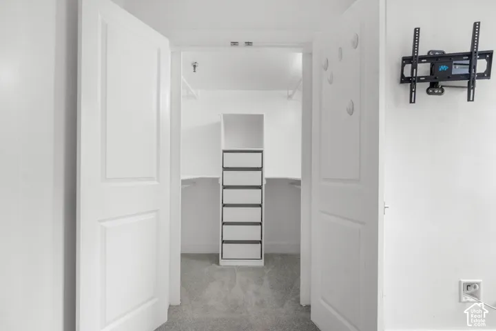 Double panel doors opening to a walk-in closet with built-in shelving, drawer storage, and hanging rods