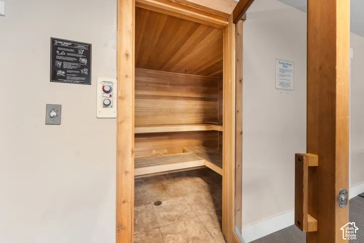 Wood-paneled sauna with built-in bench seating and tiled flooring