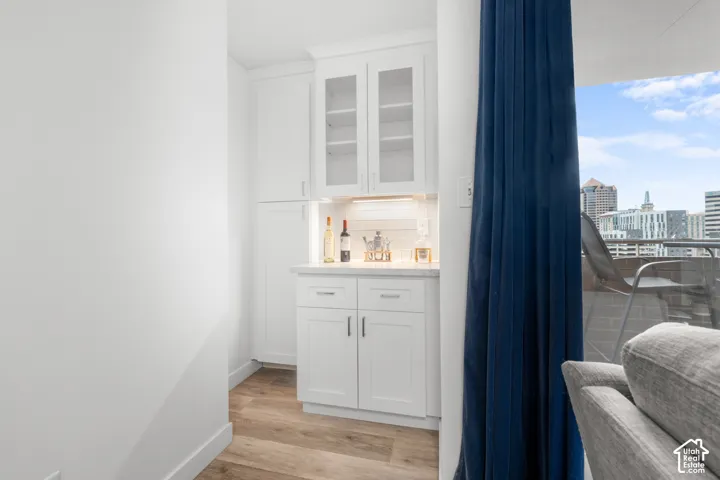 Built-in cabinetry with glass-front uppers, under-cabinet lighting, and a light-toned countertop