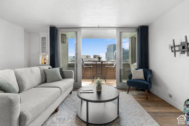 Sliding glass doors opening to an outdoor balcony, built-in white cabinetry, and wood-finish flooring