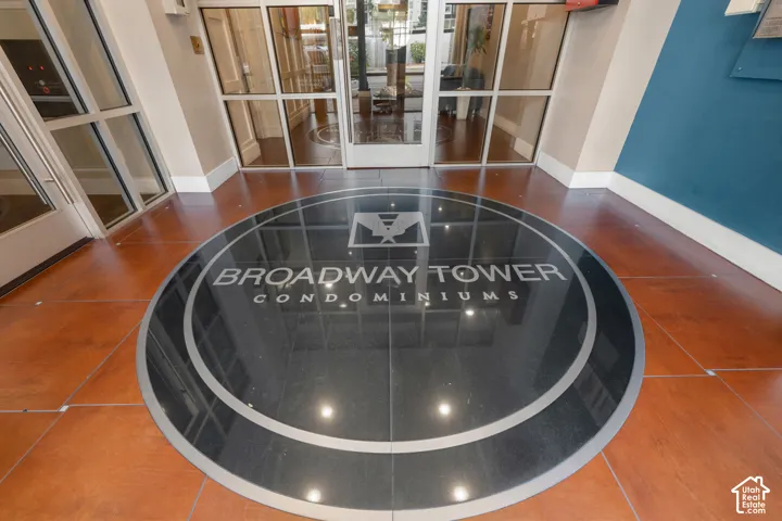 Custom floor medallion, large format floor tiling, glass entry doors, and wall paneling