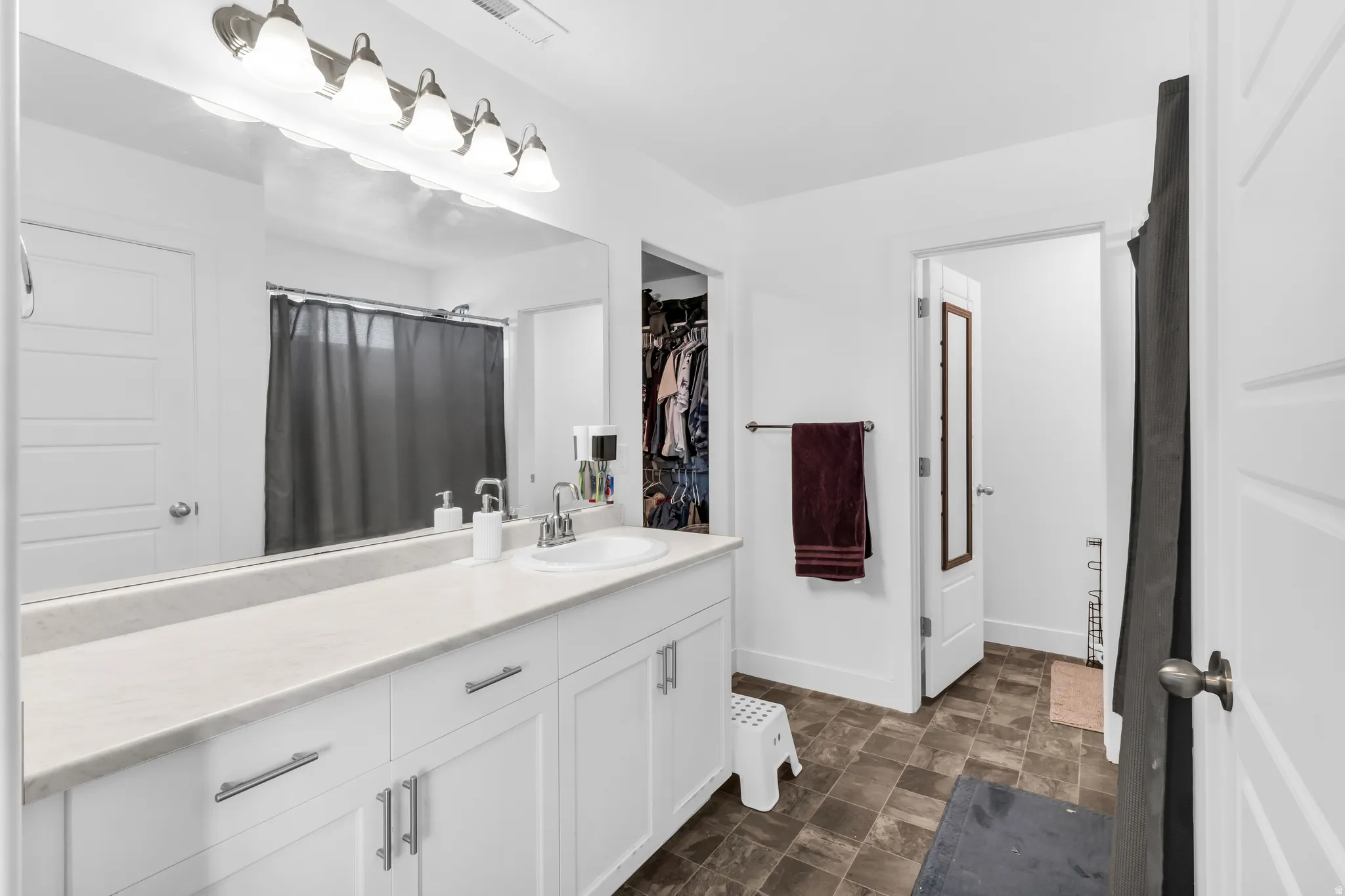 Bathroom with a white vanity, integrated sink, and white countertops