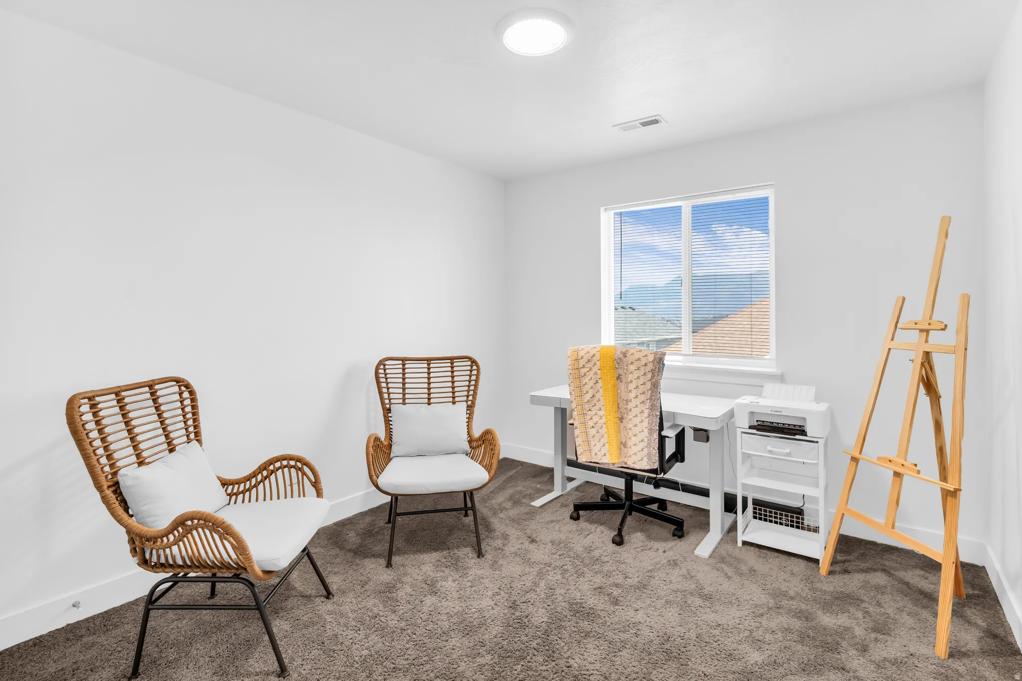Bright white walls with a single window, recessed lighting, and grey carpet flooring