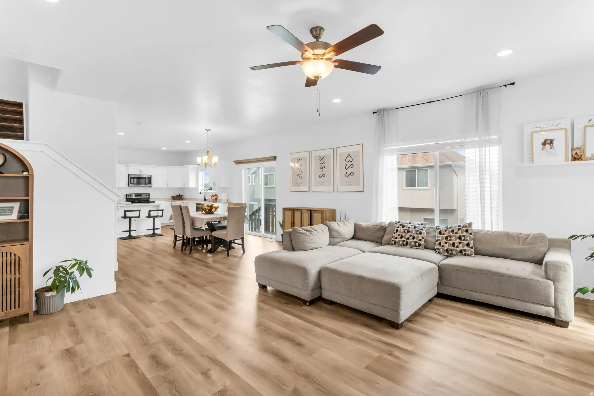 Open-concept living area featuring wood-finish flooring, recessed lighting, and a ceiling fan
