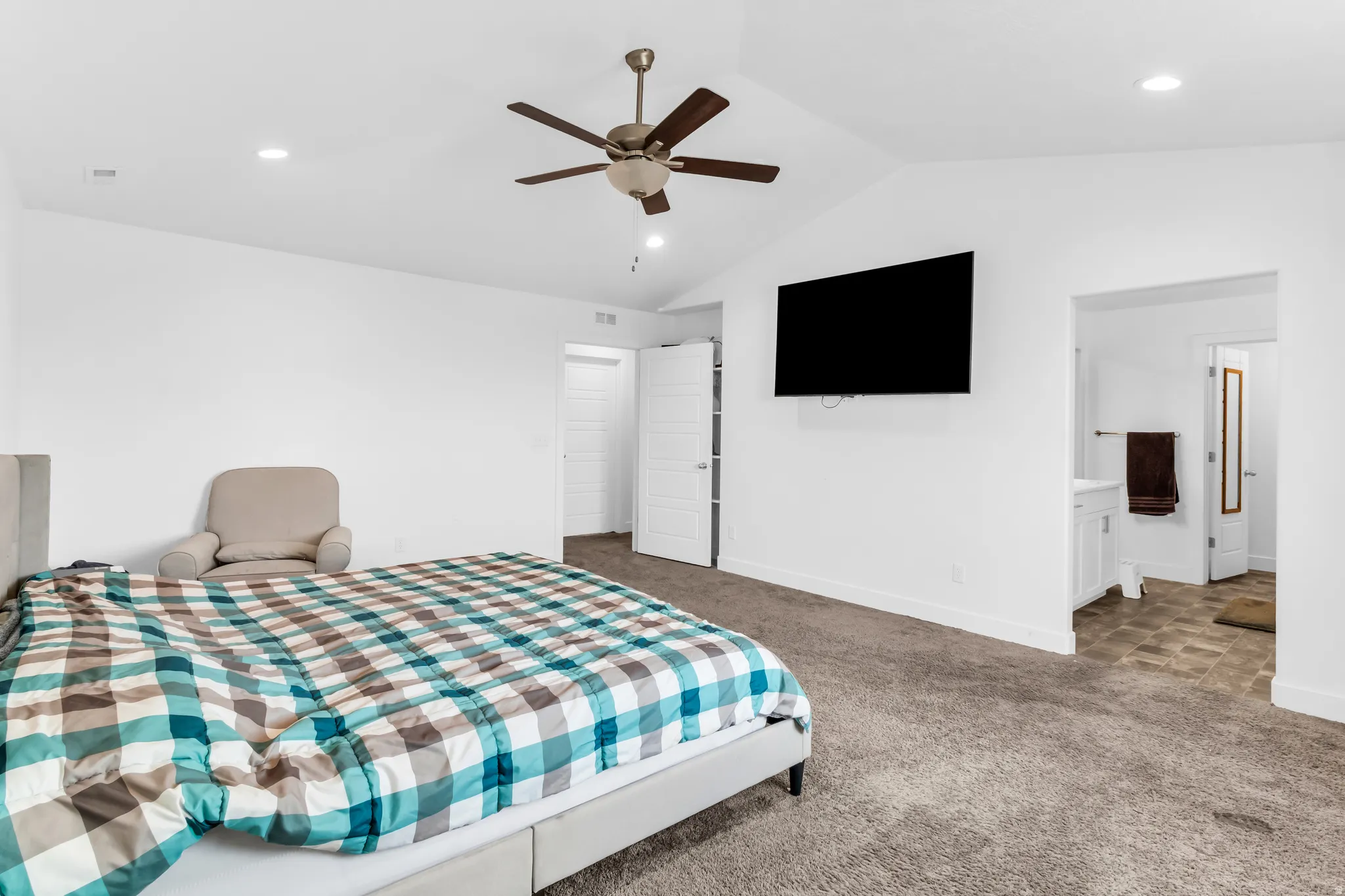Carpeted bedroom with vaulted ceilings, recessed lighting, and a ceiling fan