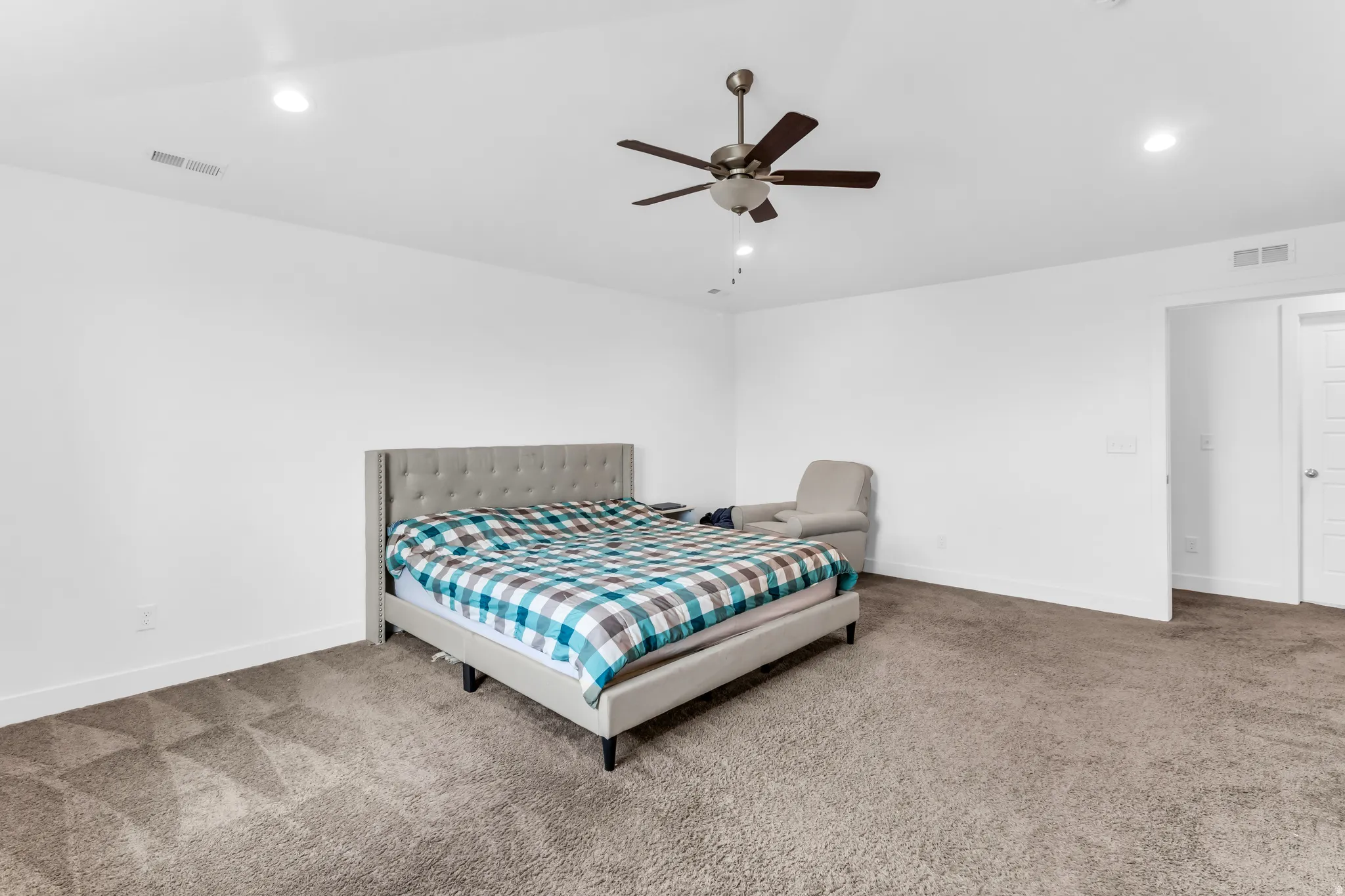 Recessed lighting, ceiling fan, and white walls