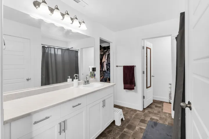 Bathroom with a white vanity, integrated sink, and white countertops