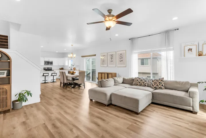 Open-concept living area featuring wood-finish flooring, recessed lighting, and a ceiling fan