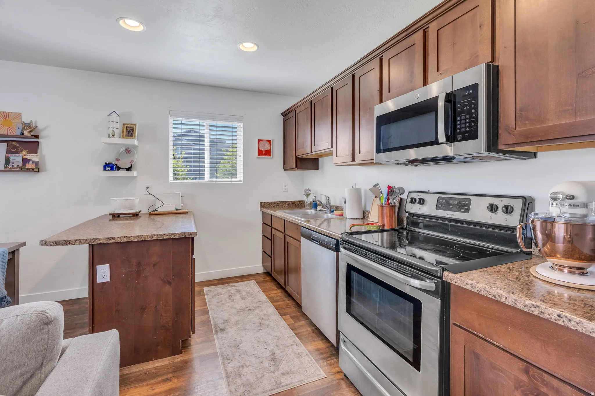 Kitchen featuring wood-finish flooring, recessed lighting, wood cabinetry, and stainless steel appliances