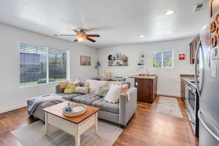 Open-concept living area with wood-finish flooring, recessed lighting, and a ceiling fan