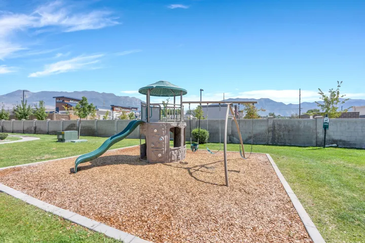 Community playground featuring a slide, swings, and climbing structure