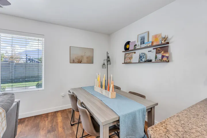 Wood-finish flooring, white walls, and a window with horizontal blinds