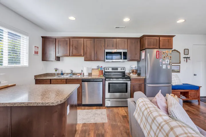 Kitchen featuring wood-finish flooring, recessed lighting, wood cabinetry, and stainless steel appliances