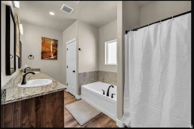 Dual vanity with granite-style countertop, undermount sinks, and matte black fixtures