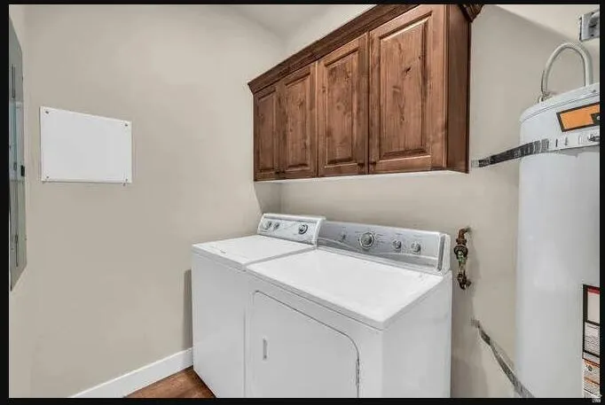 Wood-finish cabinetry offers storage above laundry appliances