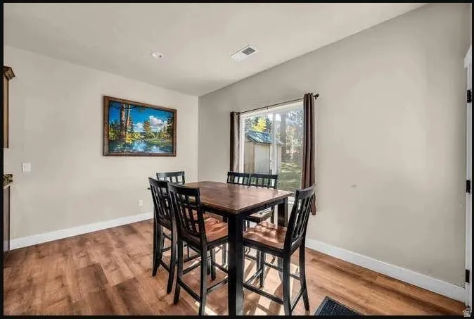 Wood-finish flooring with crisp white trim, neutral wall tones, and recessed lighting
