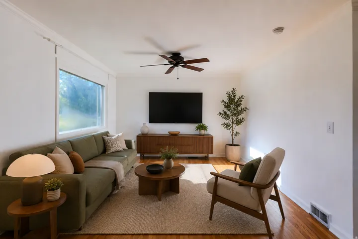Wood-finish flooring, white crown molding, large window, ceiling fan with integrated lighting, and a built-in media console