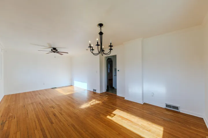 Hardwood flooring throughout, crown molding, and a ceiling fan