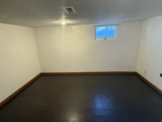 Smooth white walls with dark wood-finish flooring