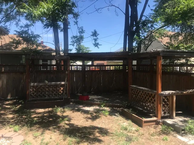 Wood-toned pergola with lattice detailing, wood fencing, and an integrated wood planter box